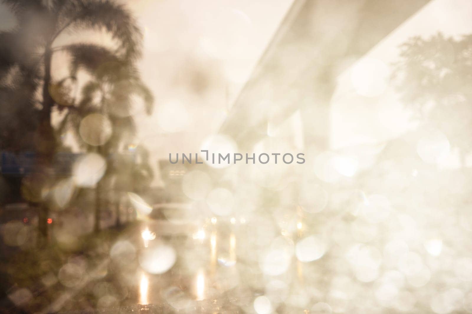 Abstract defocused bokeh road view through car window blurry with rain drops bokeh.