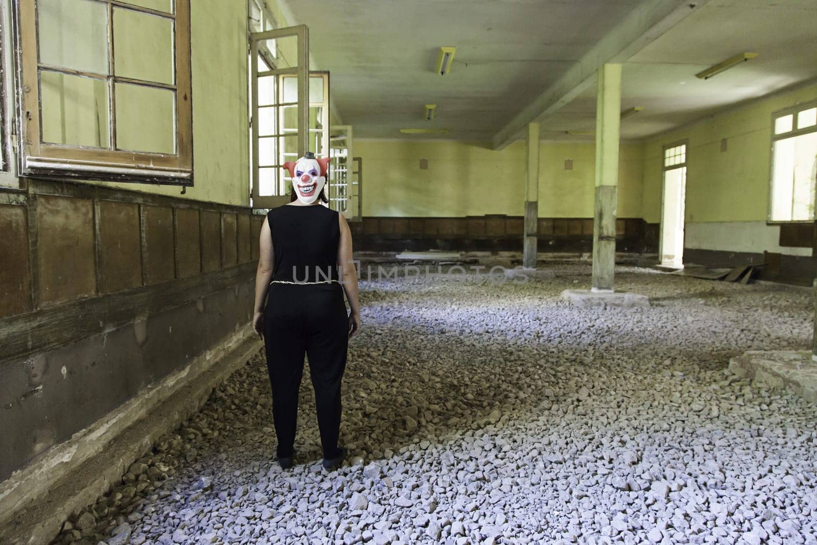 Clown in abandoned house and ruined halloween