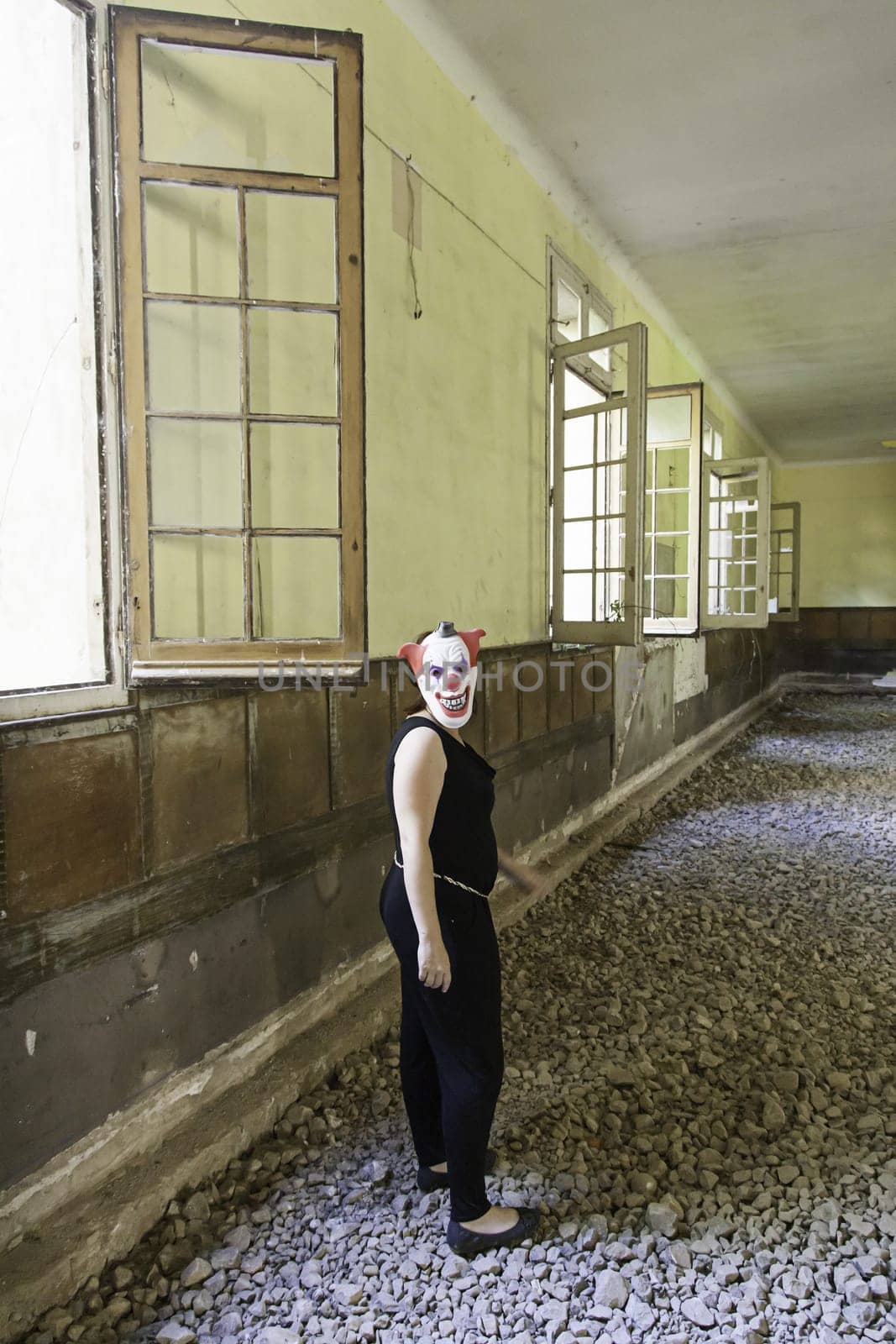 Clown in abandoned house and ruined halloween