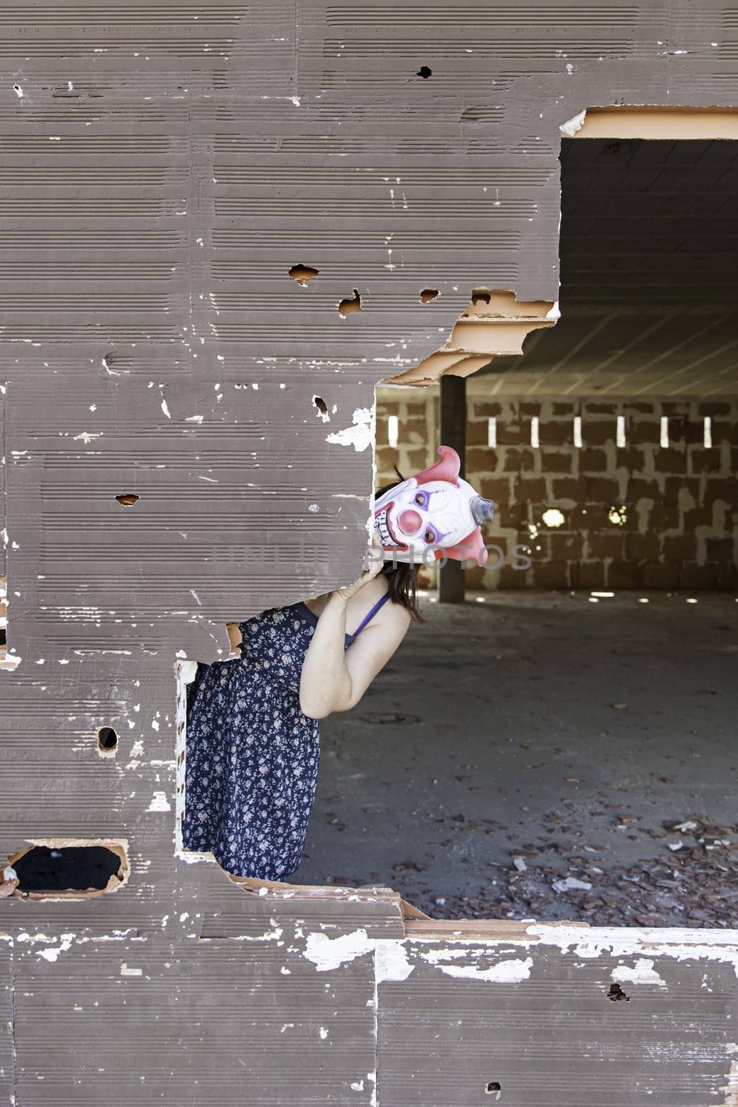 Clown in abandoned house door, fear and halloween