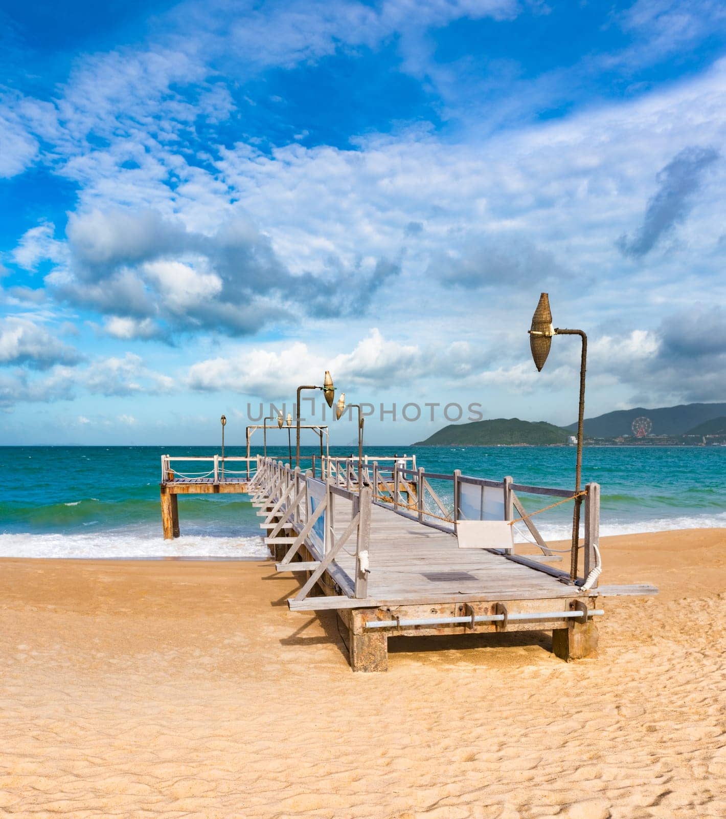 Scenic view of Nha Trang beach at sunny day. Beautiful tropical landscape. Pier on the foreground