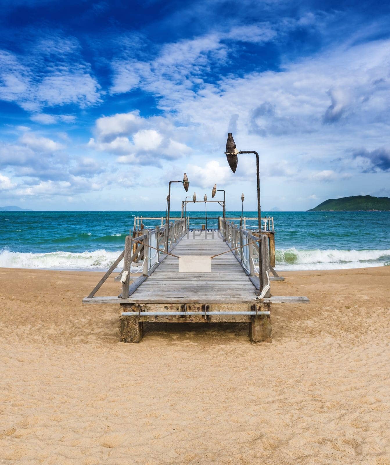Scenic view of Nha Trang beach at sunny day. Beautiful tropical landscape. Pier on the foreground