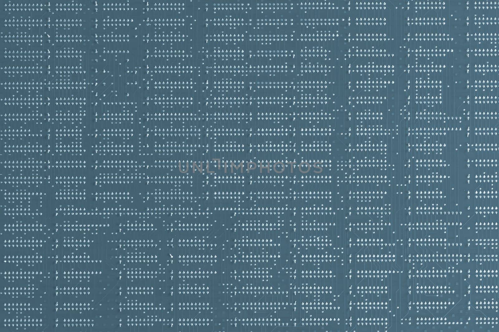 Computer technology background. Close up of blue digital electronic printed circuit board. Solder side. Macro of a PCB.