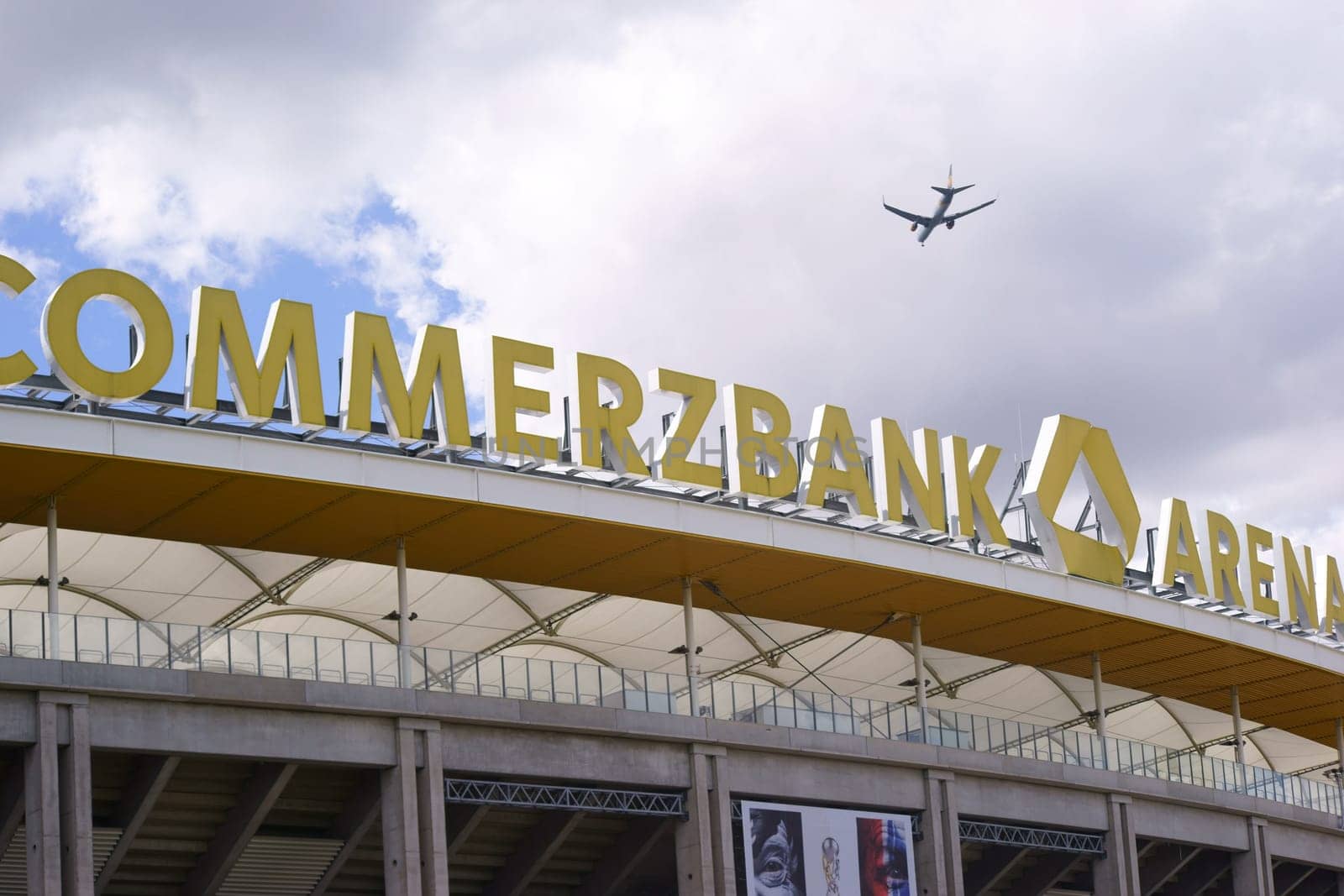 Frankfurt, Germany - August 11, 2018: A plane flying over the stadium roof and the logo of the Commerzbank Arena, the home of the football club Eintracht Frankfurt on August 11, 2018 in Frankfurt..