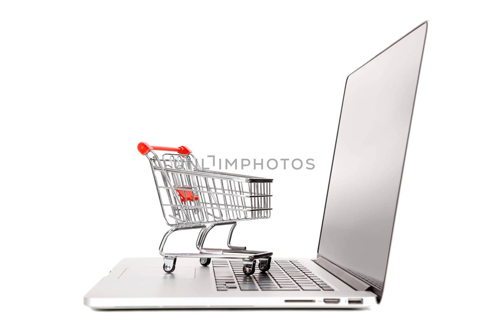 Laptop with small shopping cart isolated in white