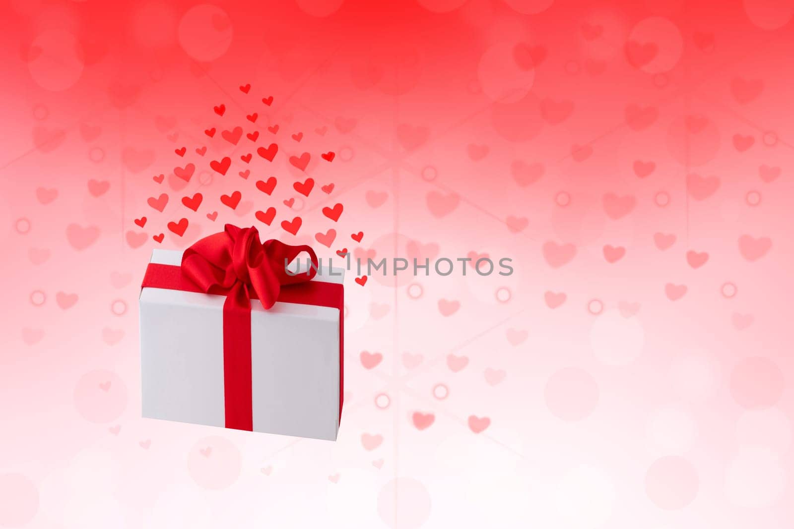 Happy Valentines or wedding day. Abstract love romantic holiday red background with hearts and a gift box with red ribbon. Template with space fro your design.