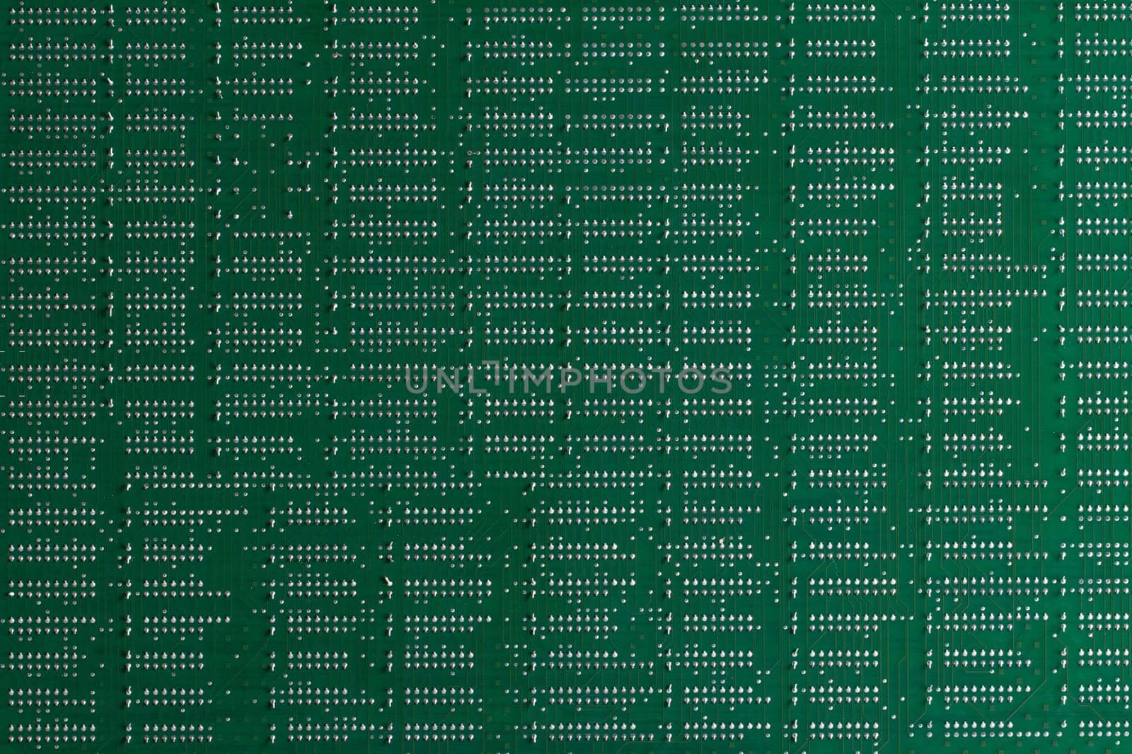 Computer technology background. Close up of green digital electronic printed circuit board. Solder side. Macro of a PCB.