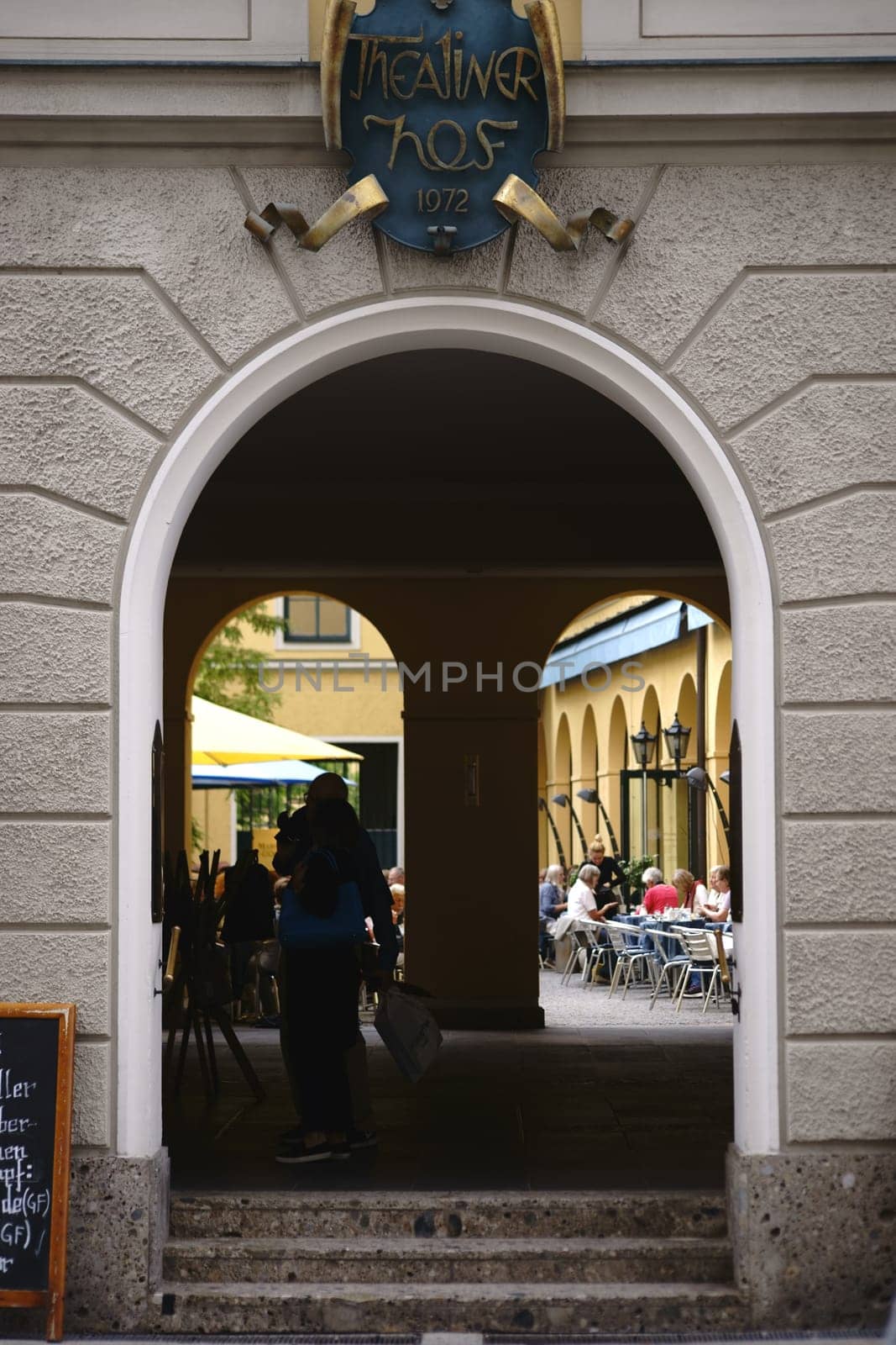 Munich, Germany - June 30, 2018: The entrance and gate to the Theatinerhof a small square with shops and restaurants on June 30, 2018 in Munich..