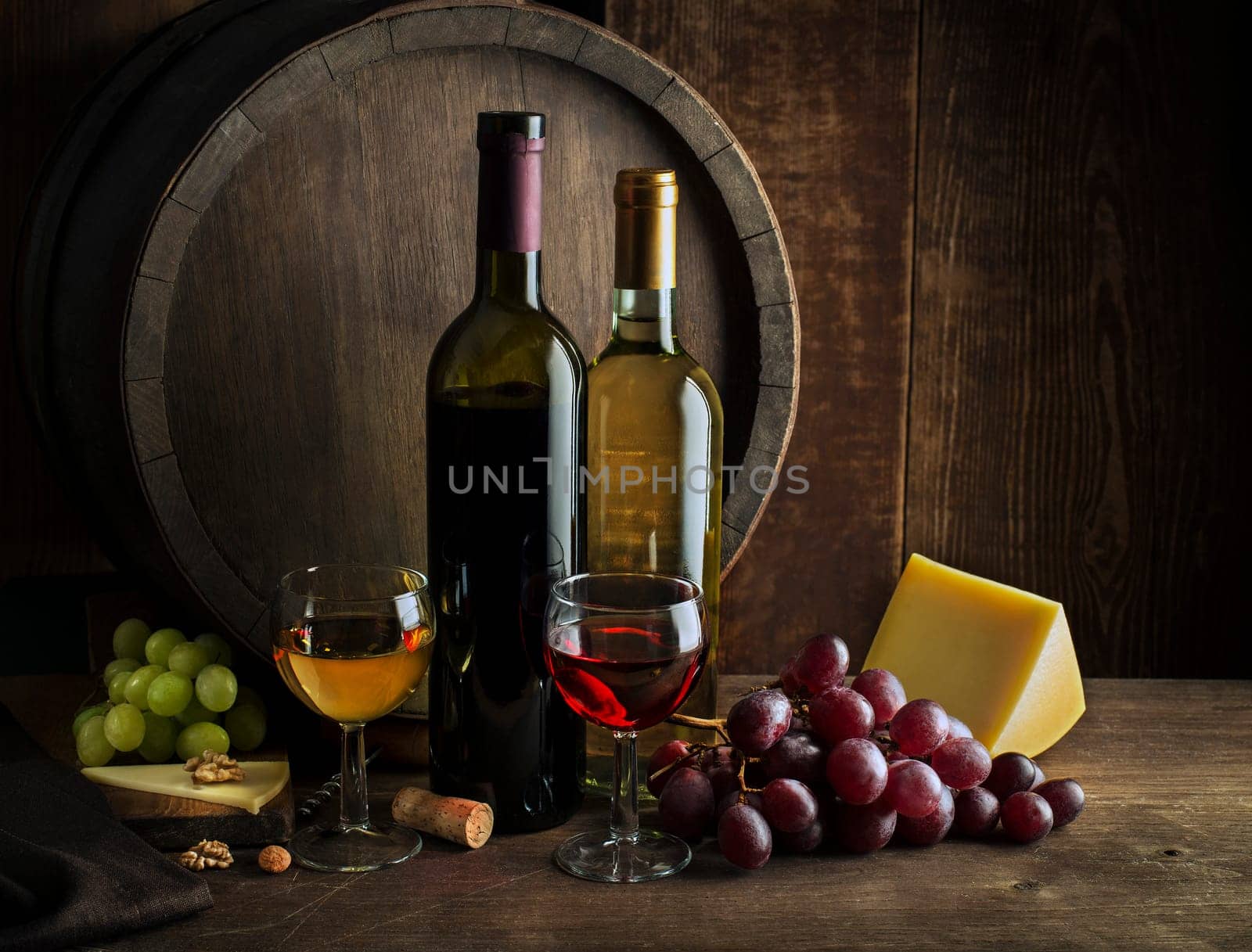 Glasses and bottles of red wine and white wine on wooden background