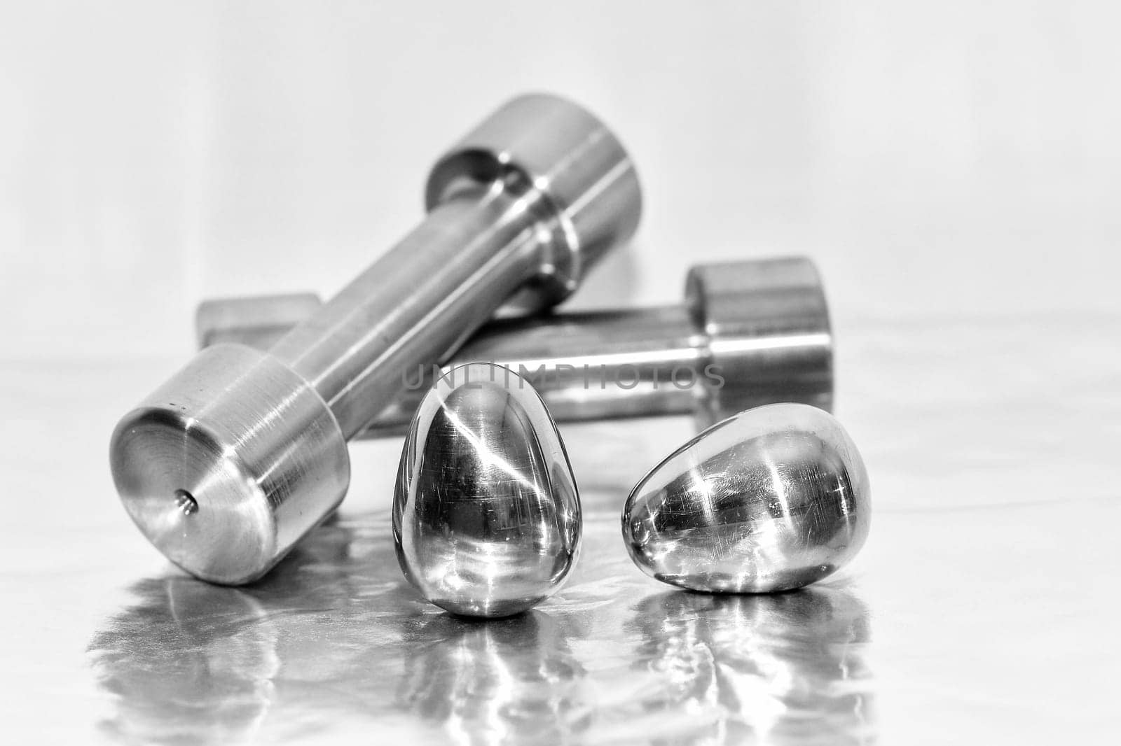 Metal dumbbells and steel eggs, the concept of sports training and the achievement of muscle strength.
