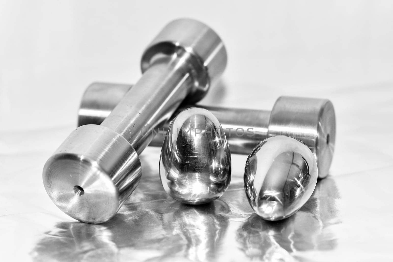 Metal dumbbells and steel eggs, the concept of sports training and the achievement of muscle strength.