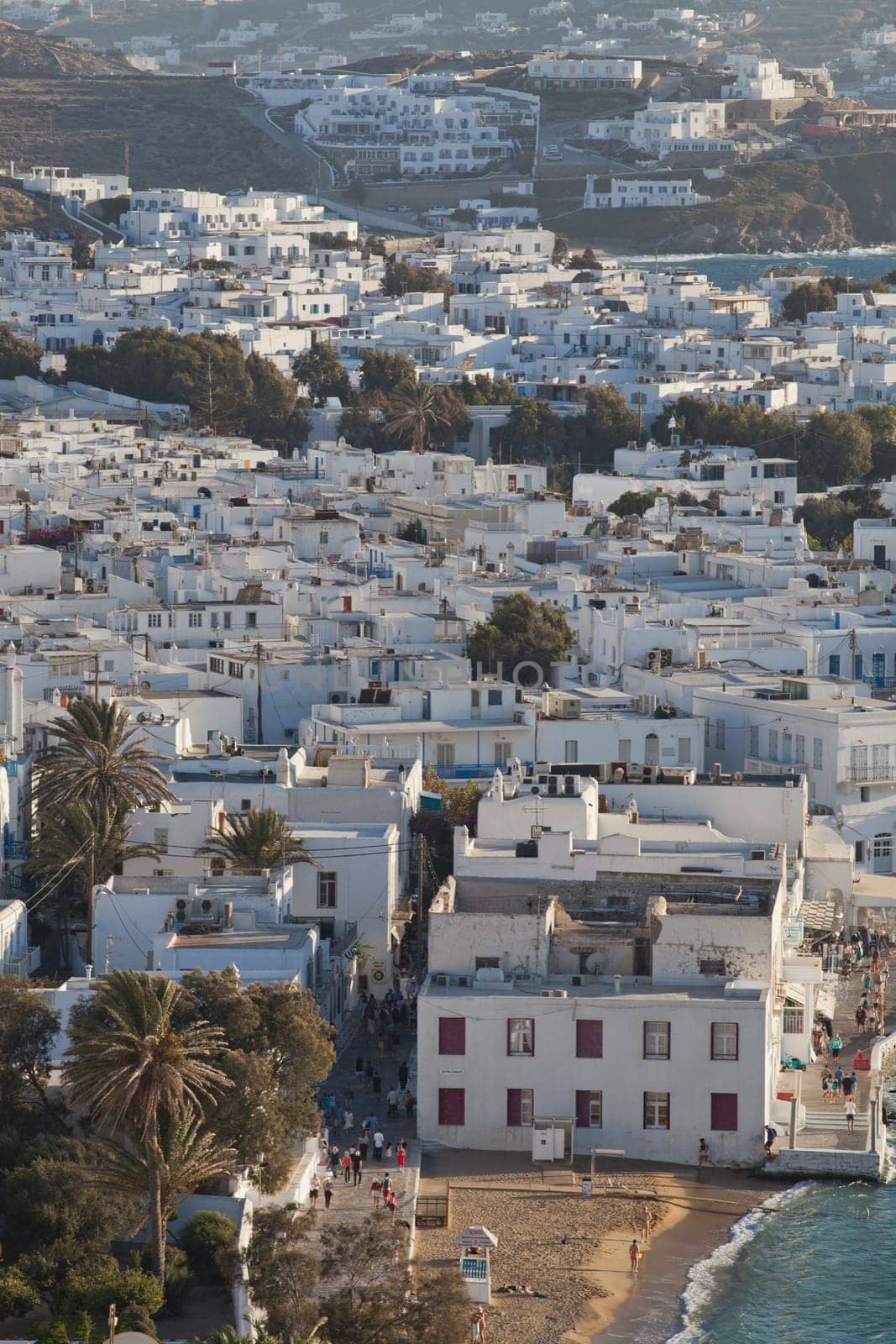 panoramic view of the Mykonos town harbor with famous windmills from the above hills on a sunny summer day, Mykonos, Cyclades, Greece