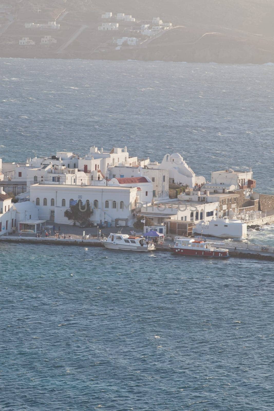 panoramic view of the Mykonos town harbor with famous windmills from the above hills on a sunny summer day, Mykonos, Cyclades, Greece