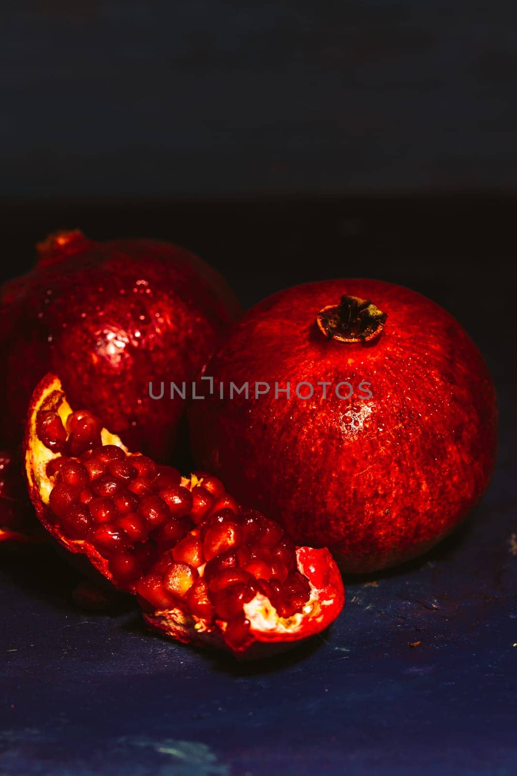 red sliced pomegranate on a blue abstraction background.