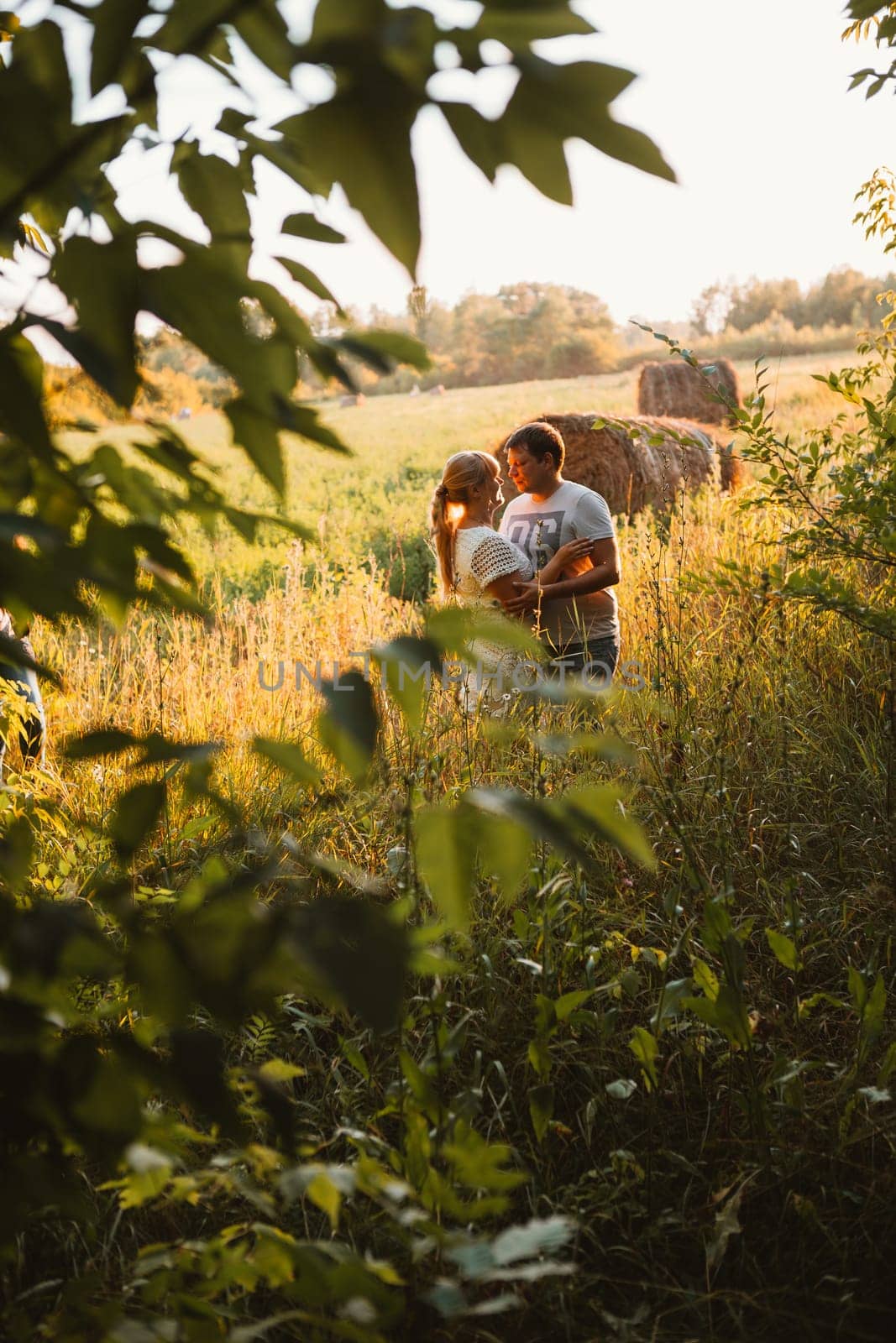 love story man and woman on the background of haystacks and sun.