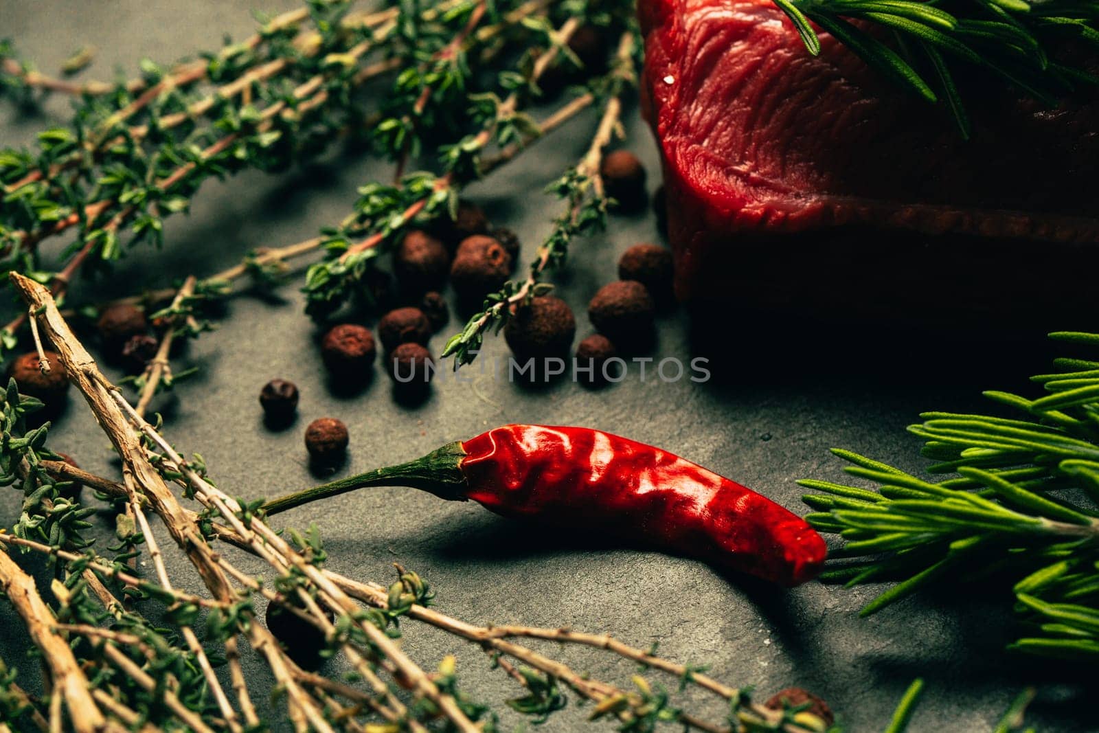 raw beef meat with spices on slate stone kitchen board.