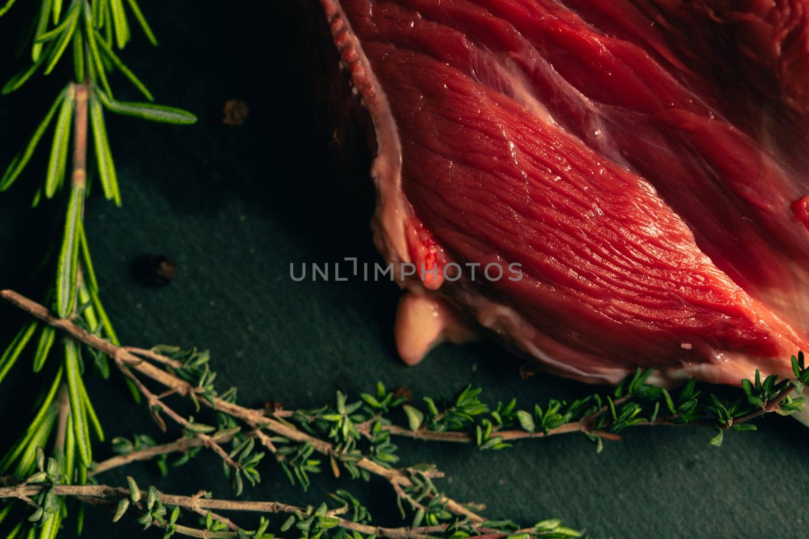 raw beef meat with spices on slate stone kitchen board.