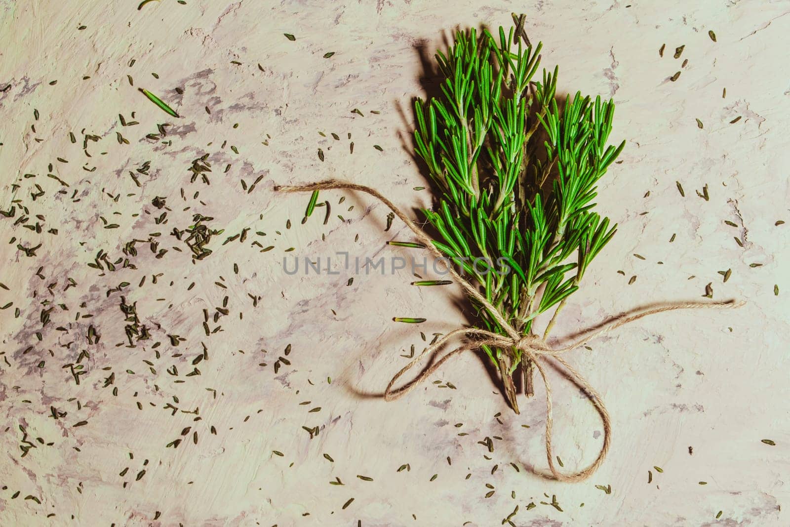 bundle of sprigs of rosemary on a textural background.