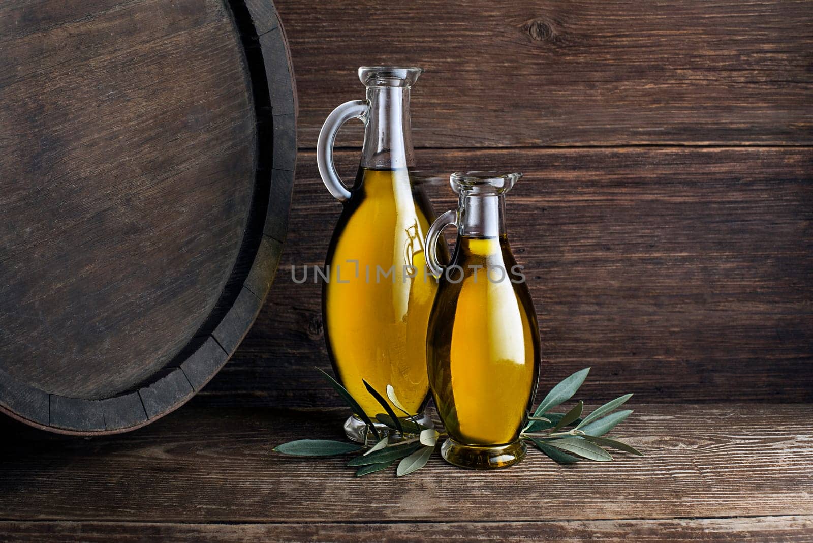 Bottles of Extra virgin healthy Olive oil with barrel background