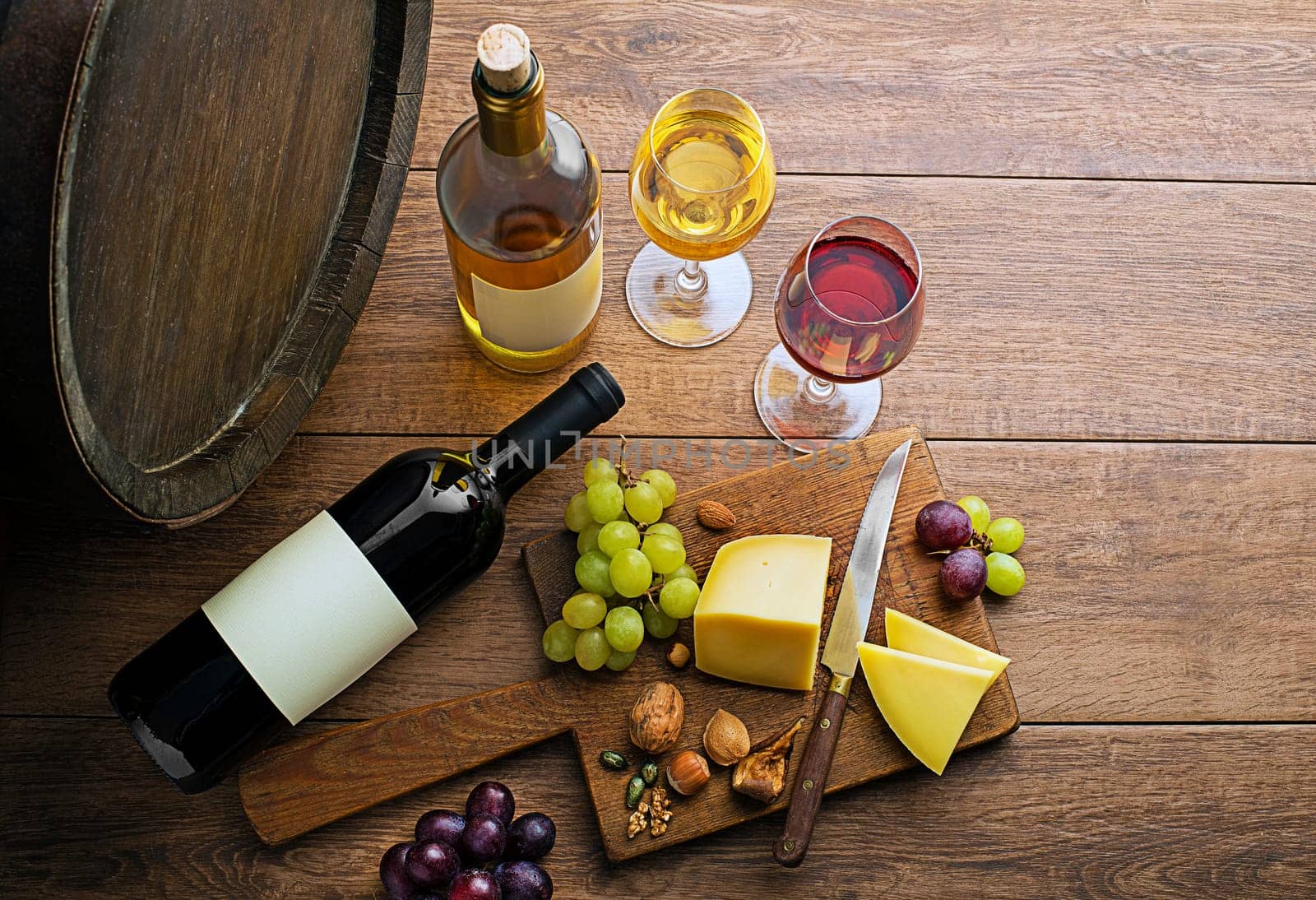 Glasses and bottles of red wine and white wine on wooden background