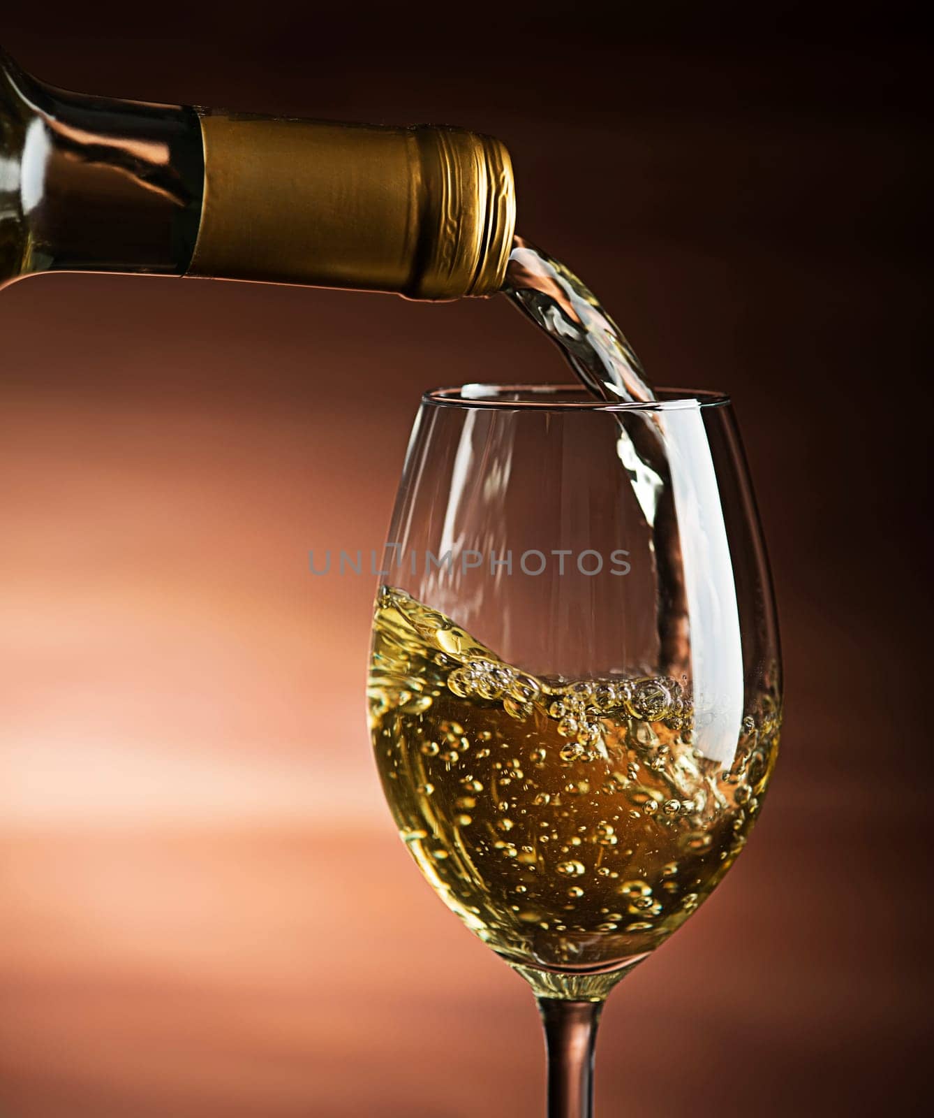 White wine pouring into wine glass, close-up - Image