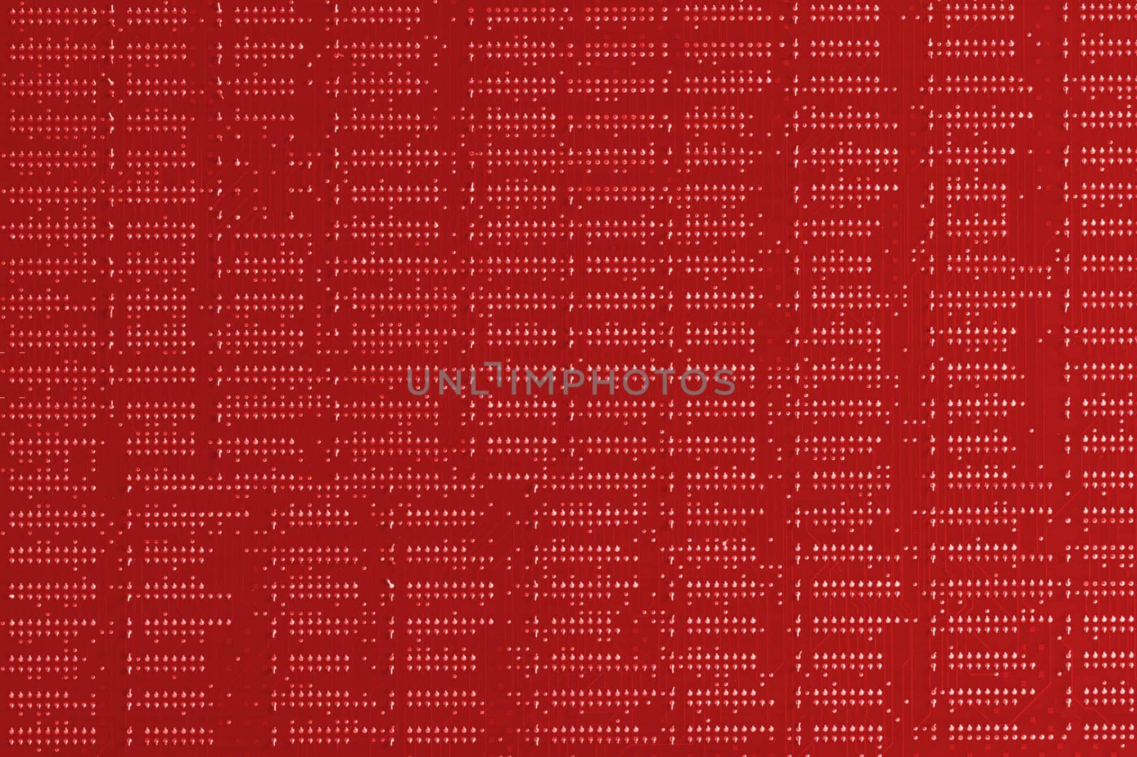 Computer technology background. Close up of red digital electronic printed circuit board. Solder side. Macro of a PCB.