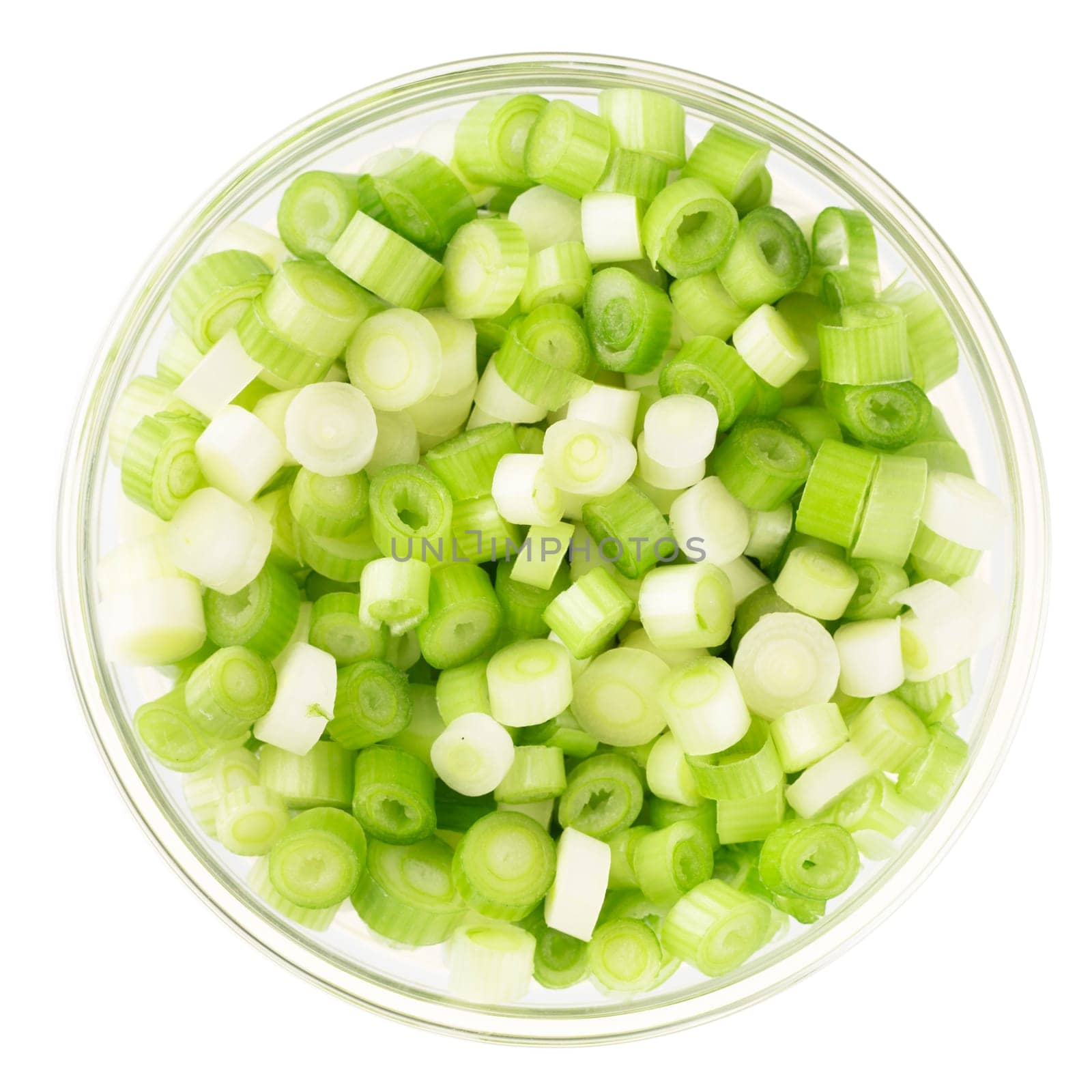 Chopped spring onions in a glass bowl and isolated on a white background.