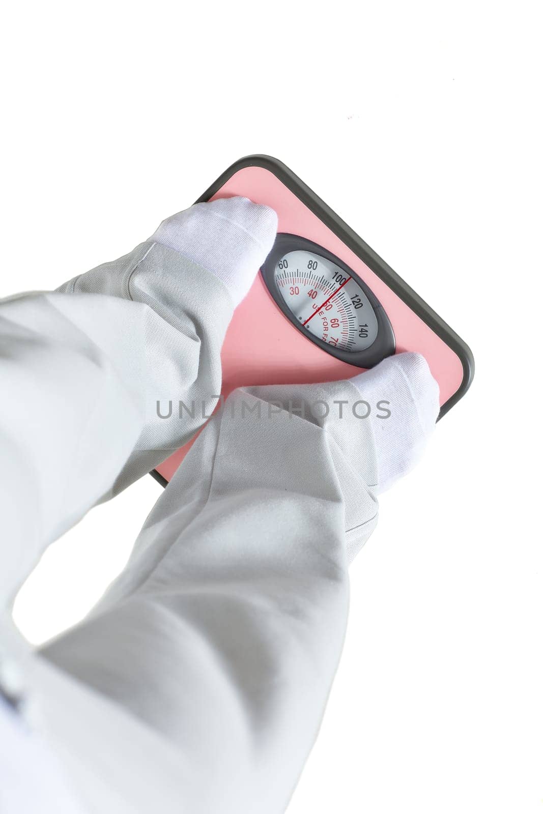 Young woman stands on scales and measures weight on a white background. Concept of healthy lifestyle.