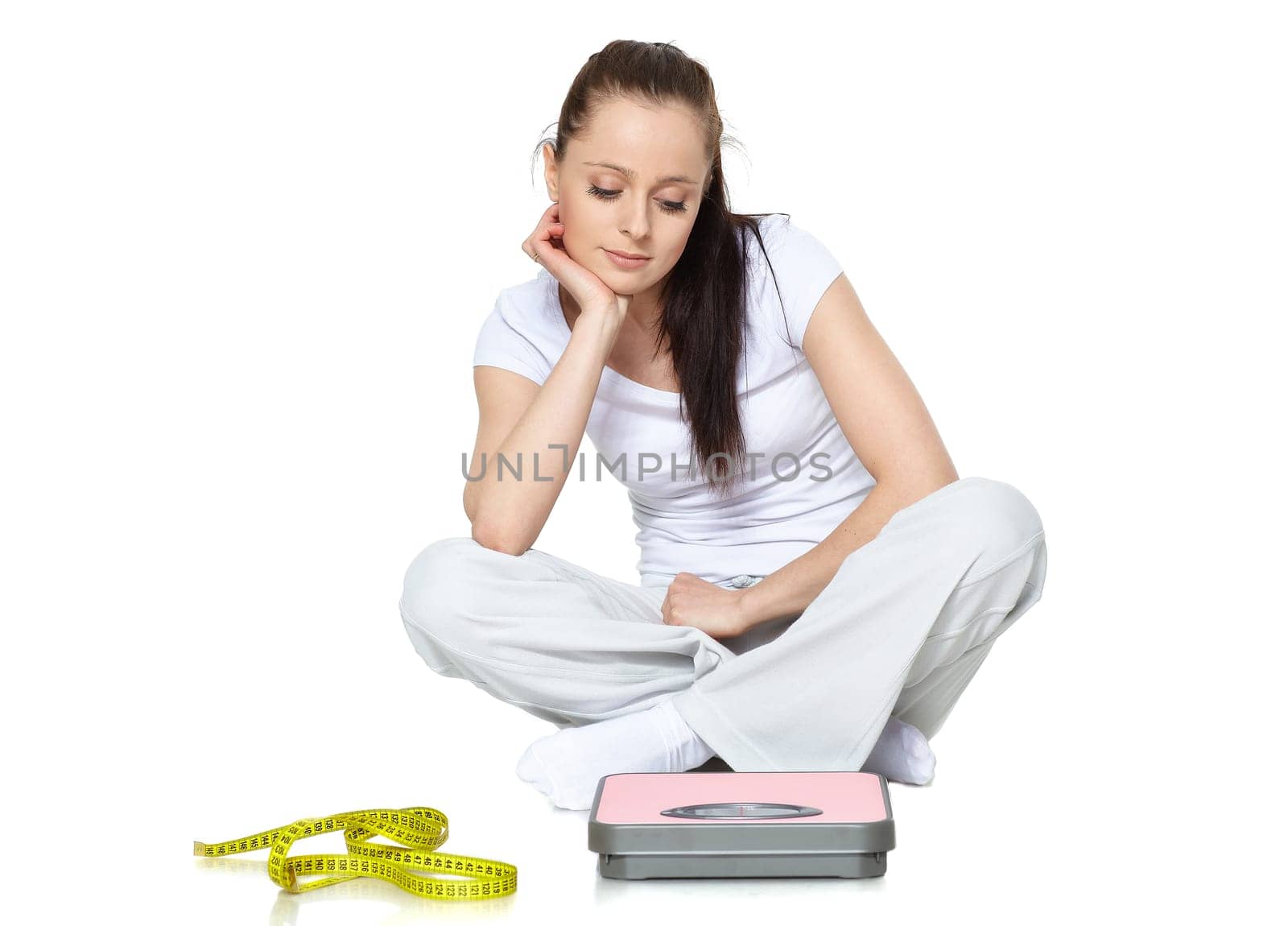 Young beautiful woman with scales on a white background.