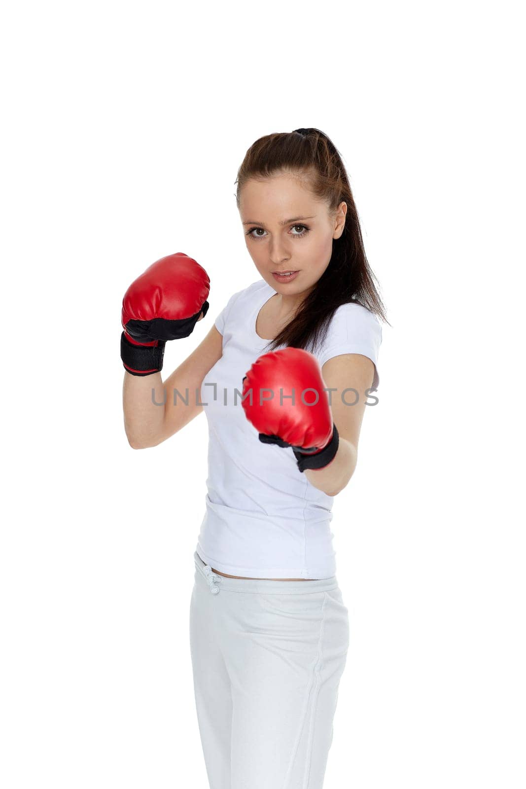 Sporty young woman in red fighting gloves on a white background.