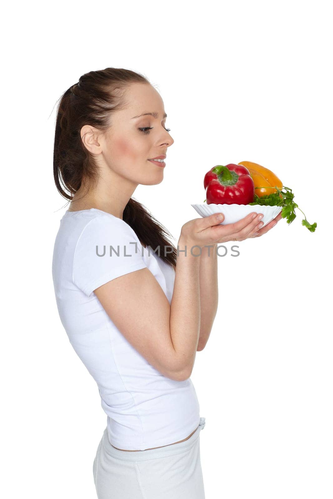 Young beautiful woman with fresh vegetables on a white background. Concept of healthy food.
