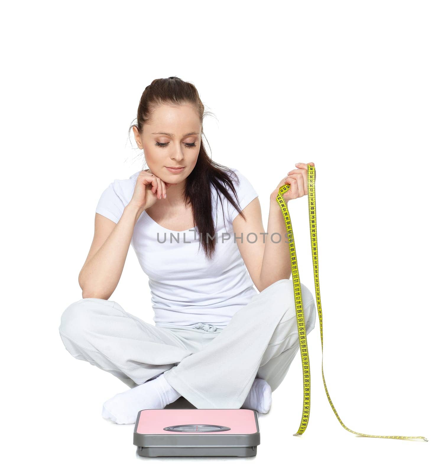Young beautiful woman with scales on a white background.