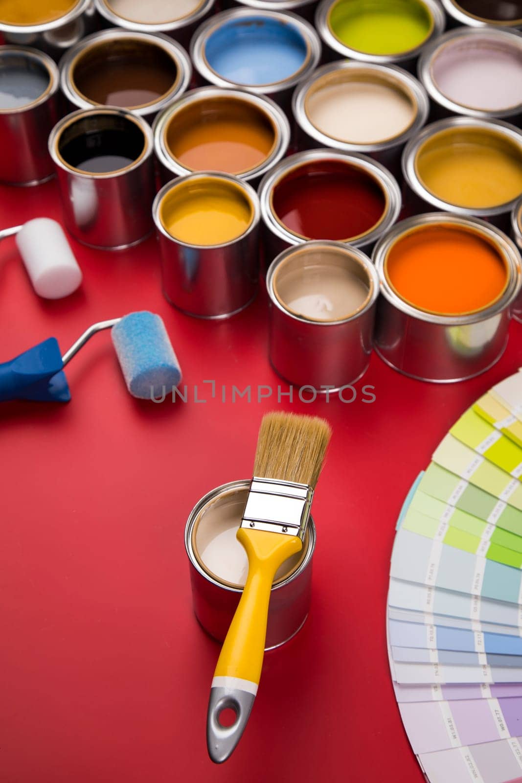 Full Buckets of rainbow colored oil paint on red background