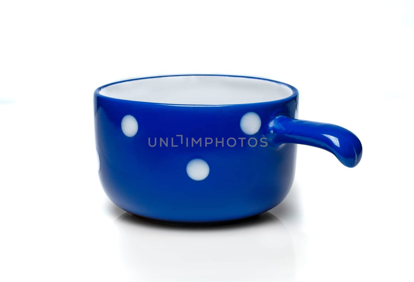Blue cup with white polka dots on a white background