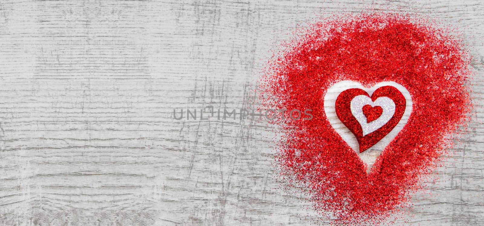Heart shaped red sparkles on wooden background