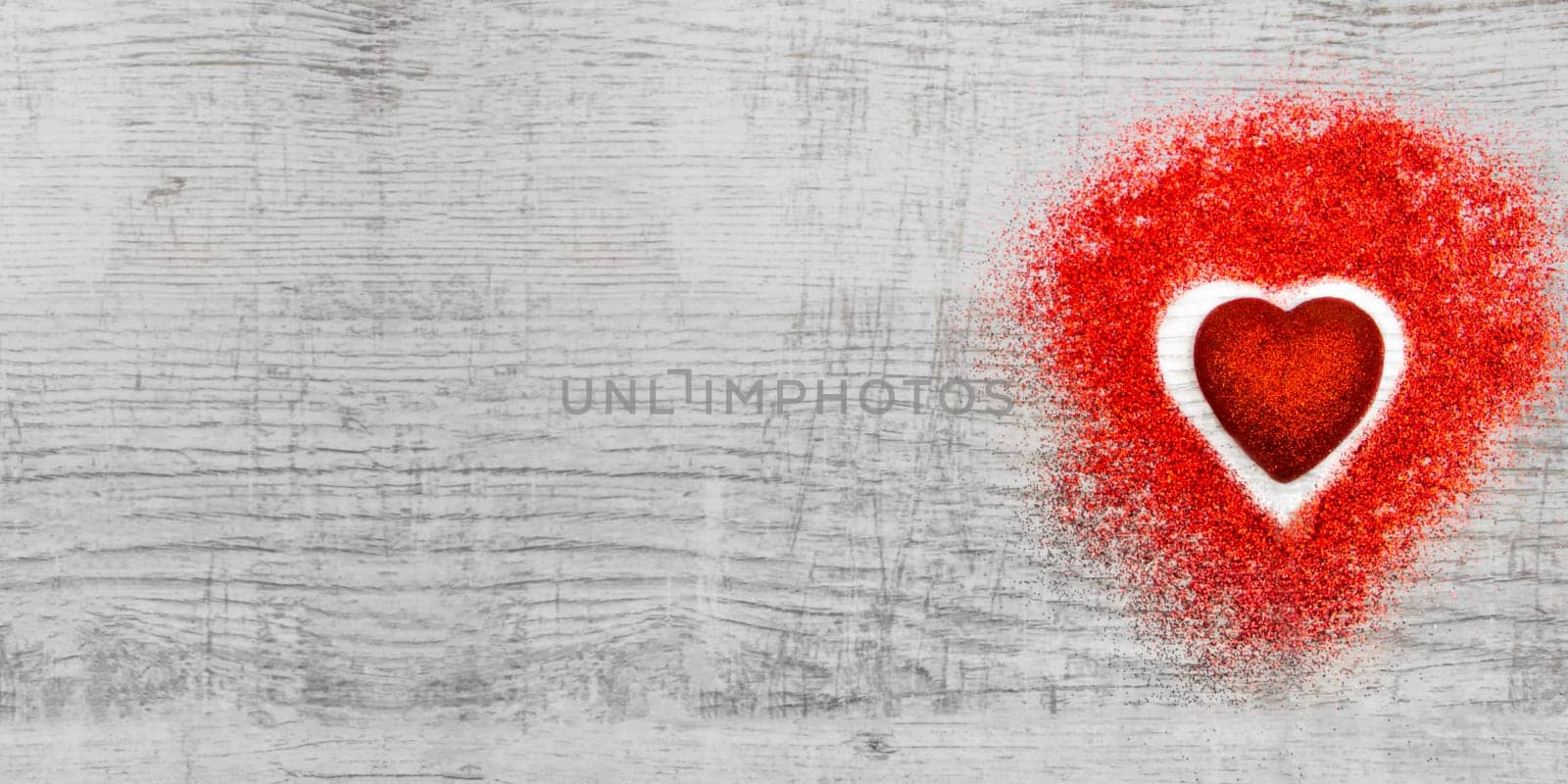 Heart shaped red sparkles on wooden background