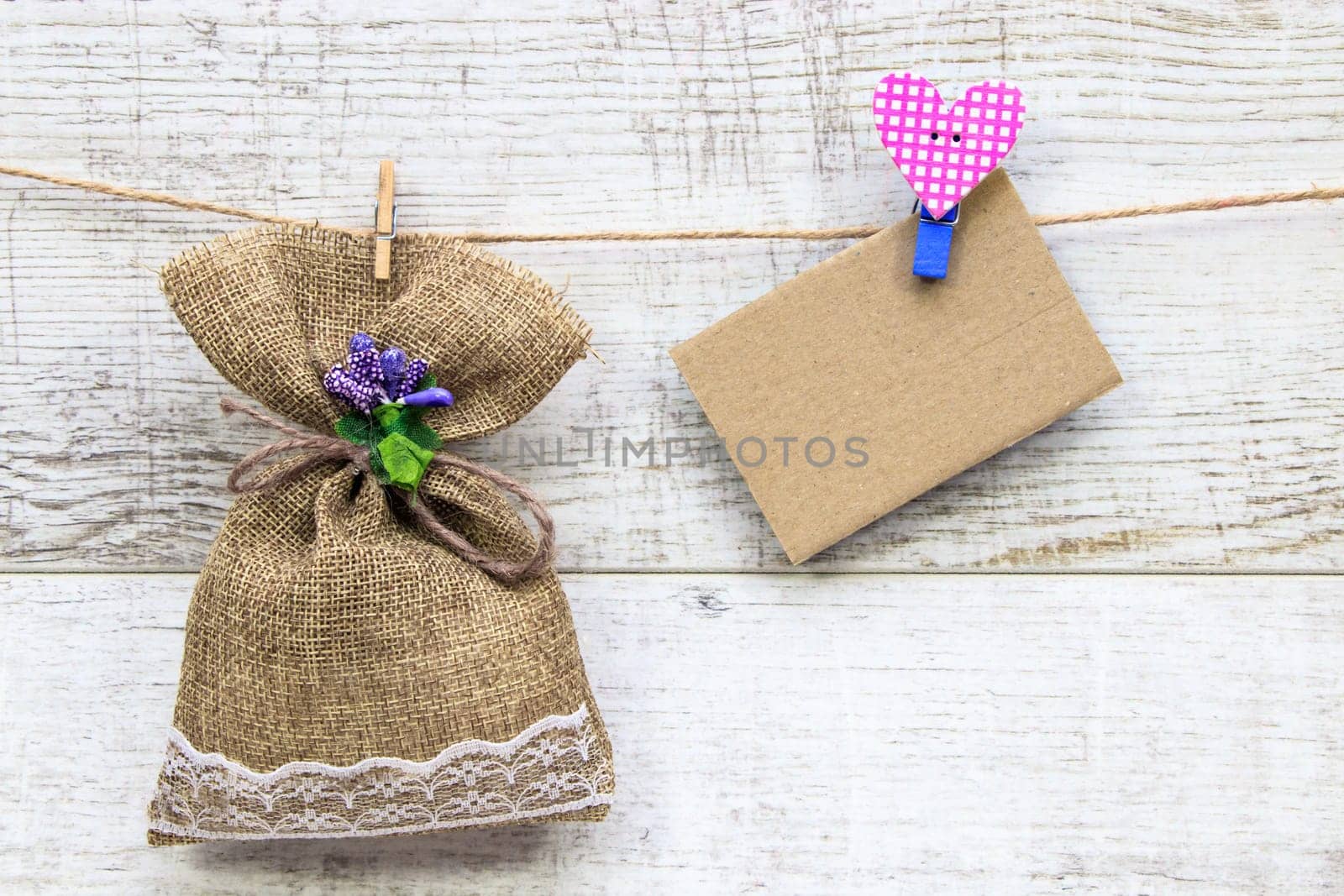 Gift sack with heart note in wooden background