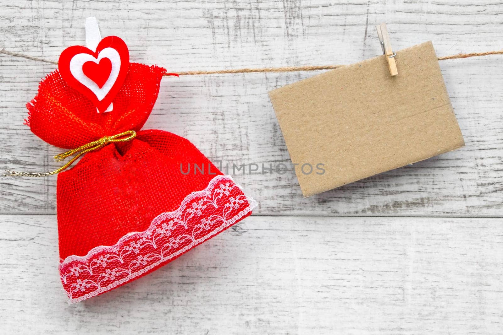 Gift sack with heart note in wooden background