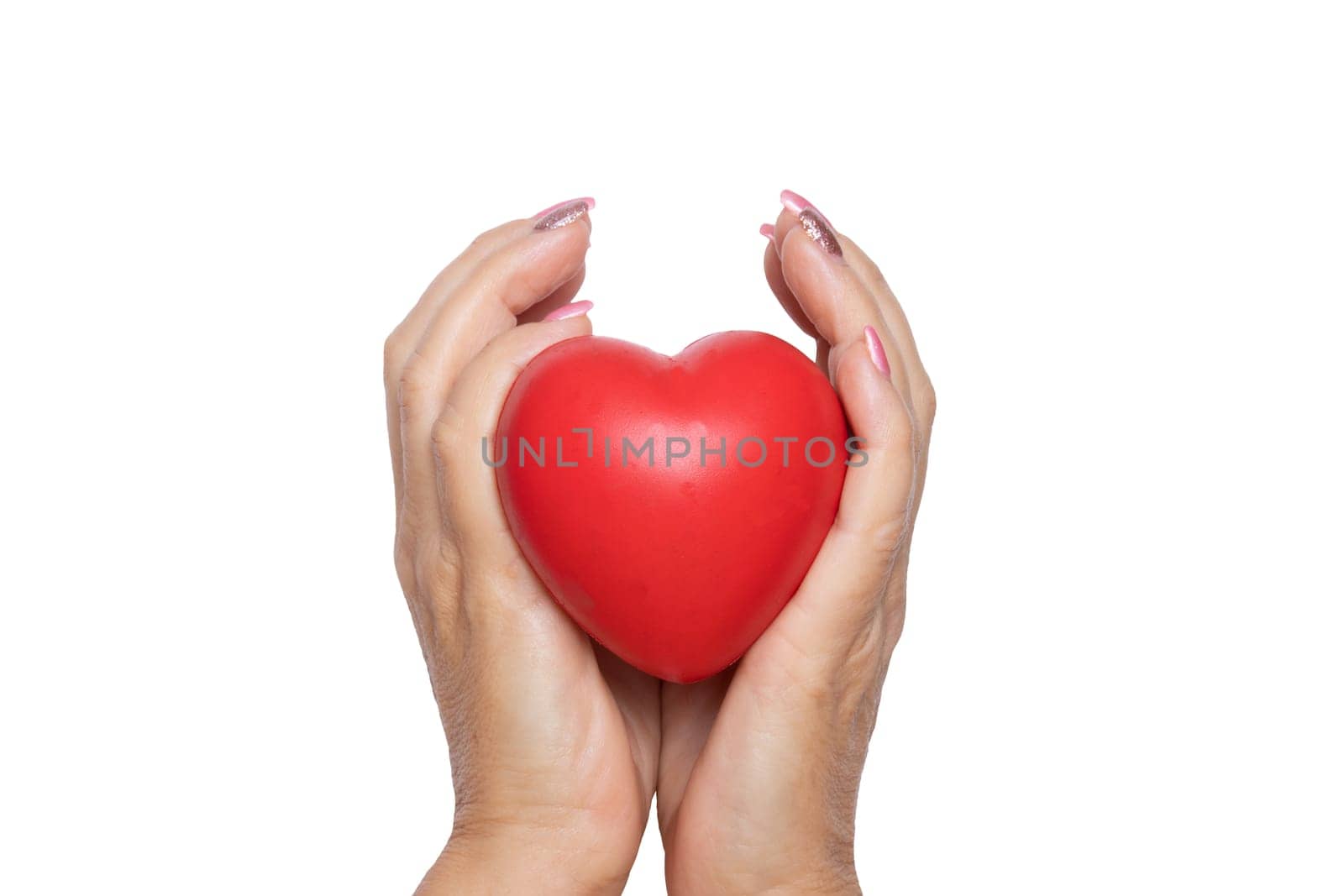 A woman holds a red symbolic heart in her palms. Close-up isolated on a white background. Concept of caring, warmth and charity.