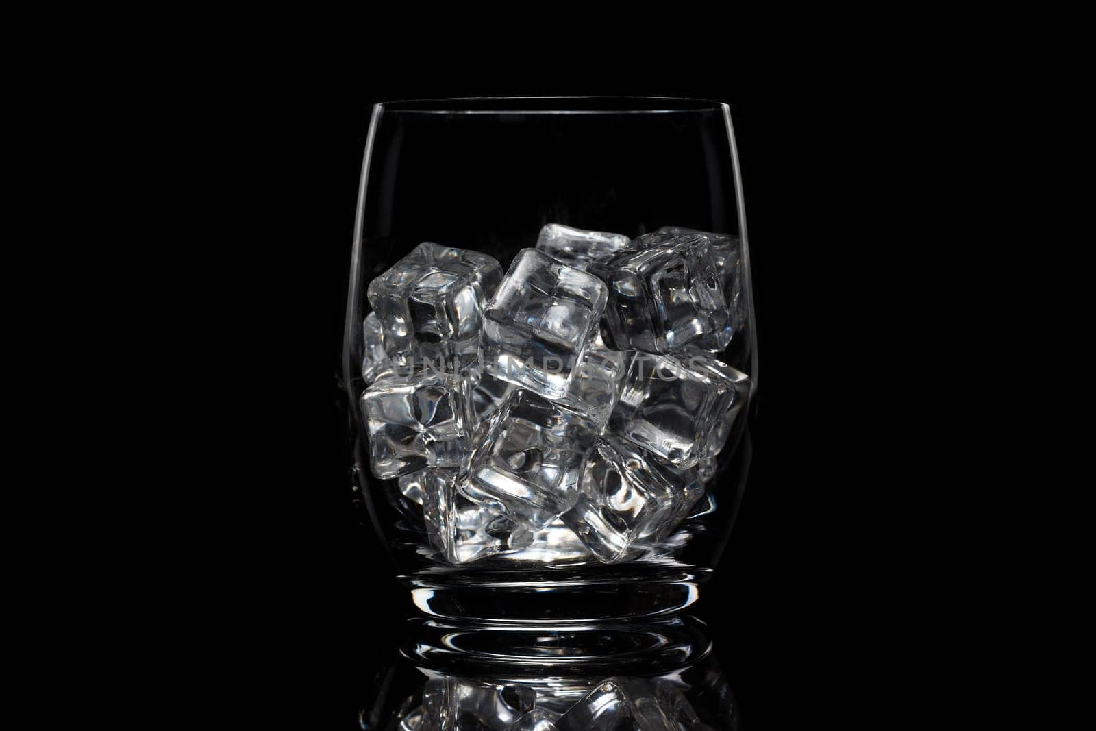Glass cup with ice on a black background
