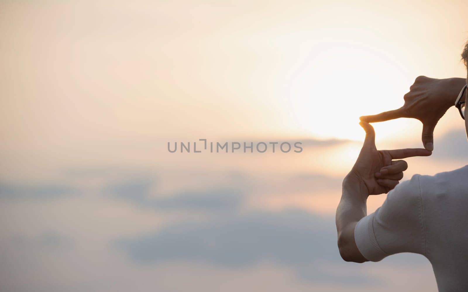 Hands making frame with sunset. Close up of woman hands making frame gesture.