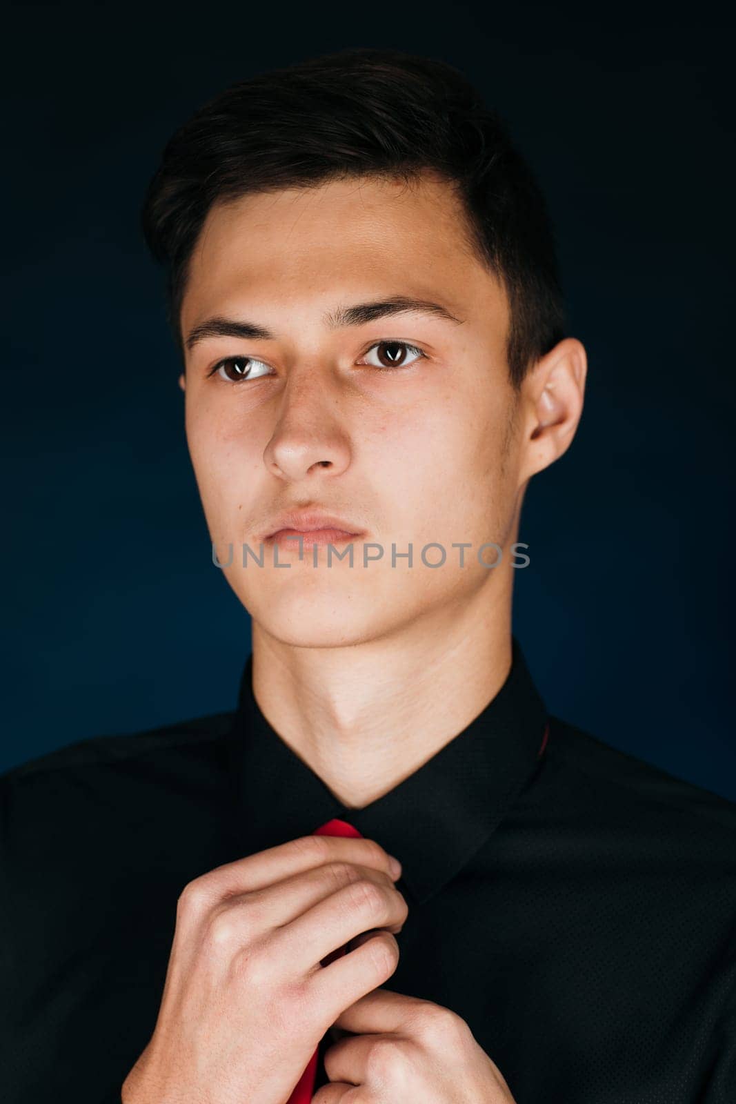 Portrait young guy on a dark studio.
