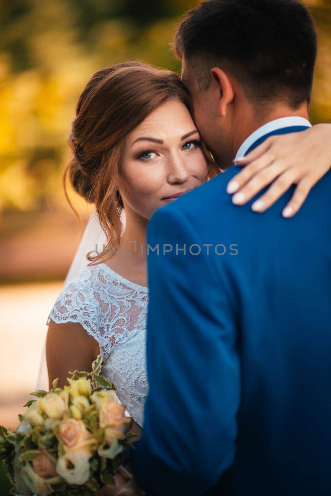 couple groom and bride hugging and kissing on nature park background.