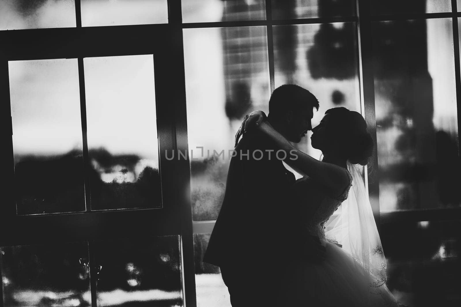 black white photo bride and groom on background clear windows.