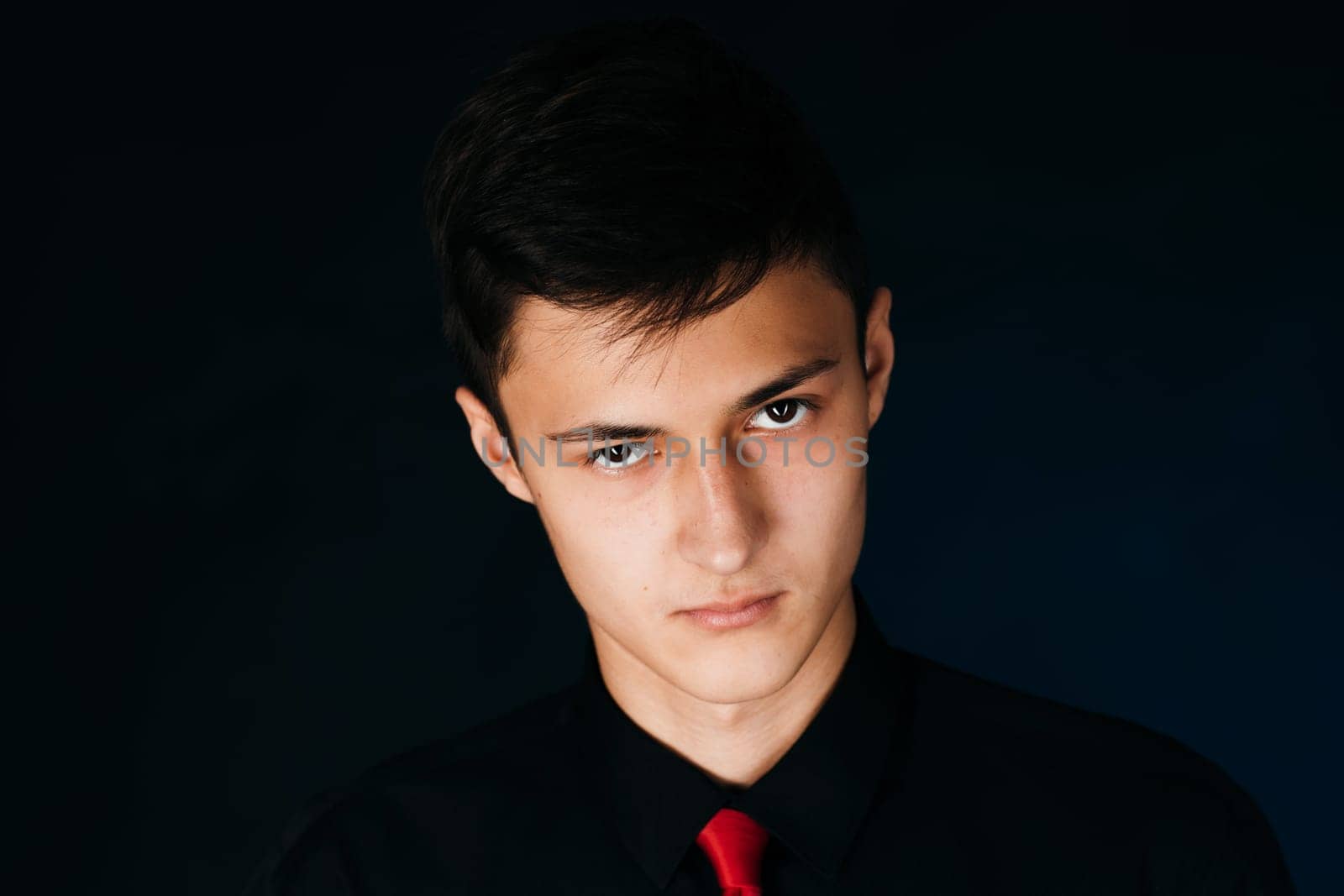 Portrait young guy on a dark studio.