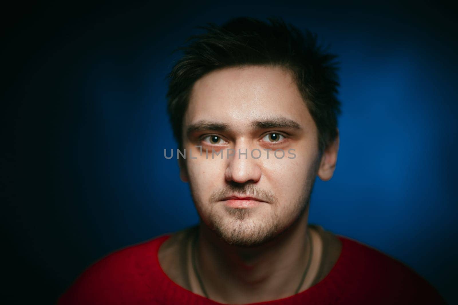 emotional young man photo in studio on blue background