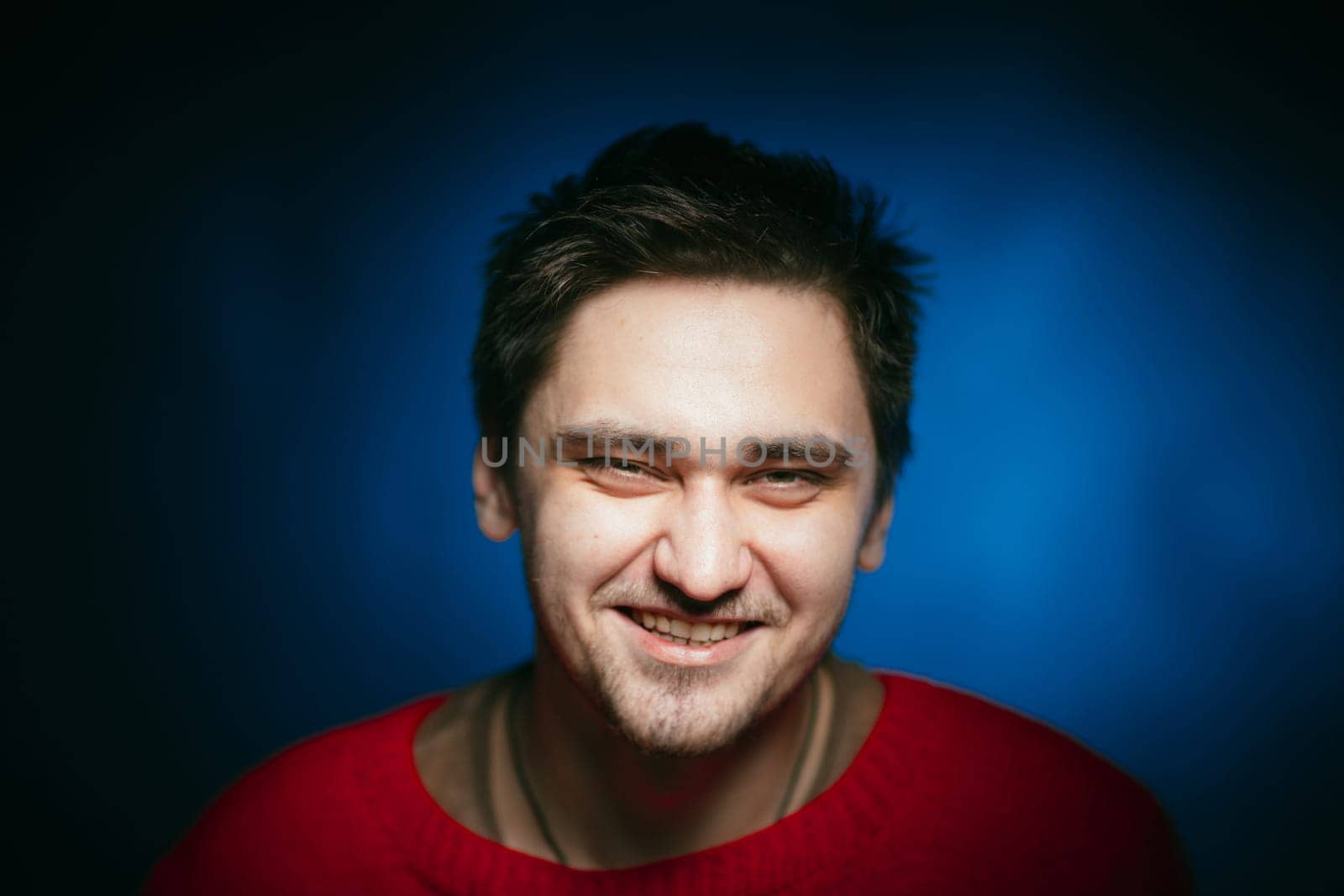 emotional young man photo in studio on blue background