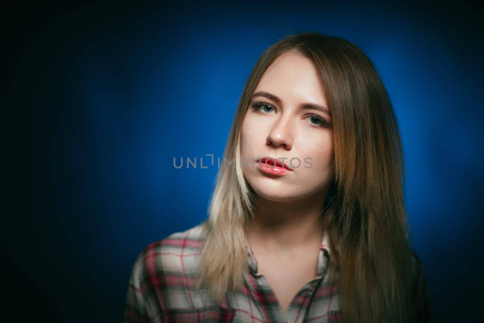 portrait smiling girl on blue background in studio.