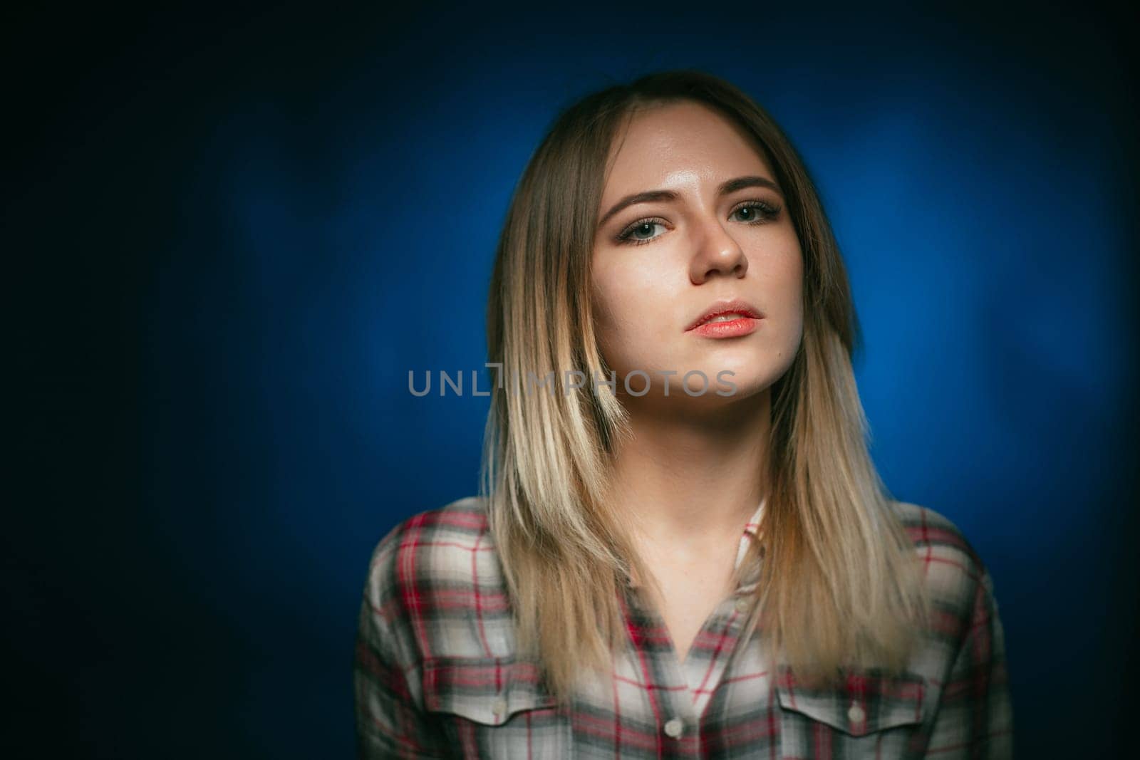 portrait smiling girl on blue background in studio.