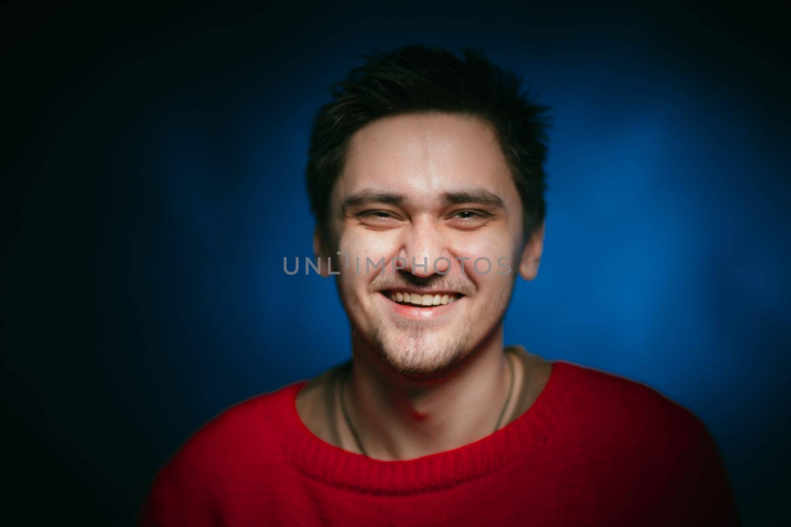 emotional young man photo in studio on blue background